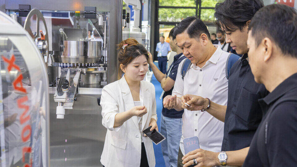 Visitors discuss tablet production solutions with Rich Packing team during the ZP-55D tablet press demonstration